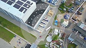 Industry with low carbon footprint. Industrial warehouses with solar panels on the roof. Technology park and factories from above