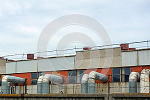 Industry plant with pipes and tubes. Outside view of manufacturing complex under blue cloud sky. Concrete walls, metal frames,