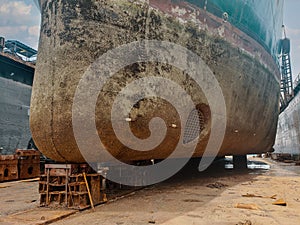 Industry view - Ocean Vessel in the dry dock in shipyard. Old rusty ship under repair