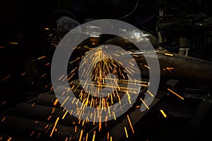 Industry worker cutting metal with grinder