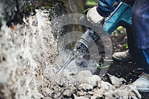 Industry worker details. Male worker using jackhammer pneumatic drill machinery