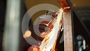 Industry worker grinding metal with angle grinder