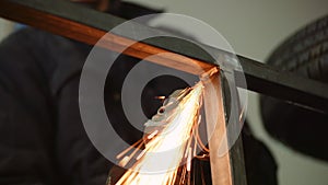 Industry worker grinding metal with angle grinder
