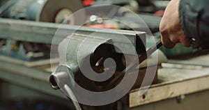 Industry worker sanding metal with metal file