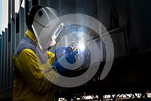 Industry worker with welding steel to repair container structure