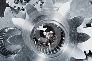 Industry workers inside giant cogs axles