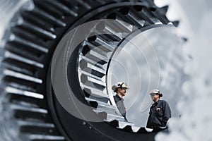 Industry workers inside giant gears