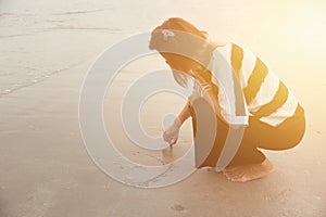 Indy women alone draw heart shape on the beach