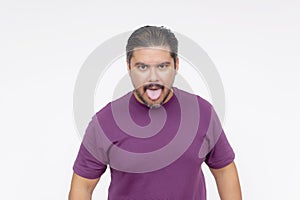 An inept and childish male sticking his tongue out, staring at the camera. Making a mockery of himself. Wearing a purple waffle photo