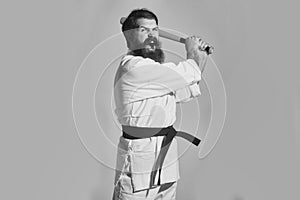 Inept karate. bearded shouting karate man in kimono with green baseball bat photo