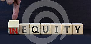 Inequity or equity symbol. Turned wooden cubes and changed the concept word Inequity to Equity. Beautiful grey table grey