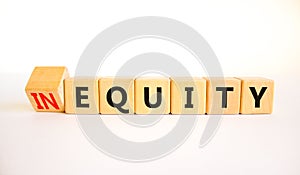 Inequity or equity symbol. Turned wooden cubes and changed the concept word Inequity to Equity. Beautiful white table white