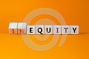 Inequity or equity symbol. Turned wooden cubes and changed the word inequity to equity. Business and inequity or equity concept.