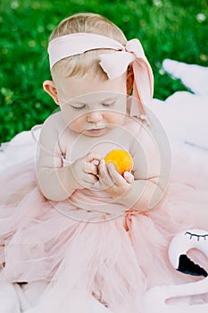 Infancy and age concept . beautiful happy baby in pink dress in the park playing