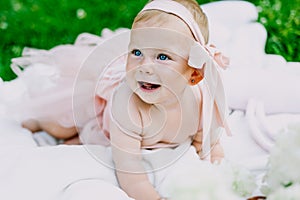 Infancy and age concept . beautiful happy baby in pink dress in the park playing