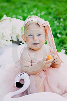 Infancy and age concept . beautiful happy baby in pink dress in the park playing