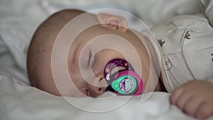 infancy, childhood, development, medicine and health concept - close-up face of newborn chubby sleeping baby 6 month