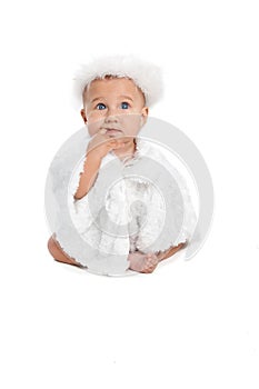 Infant in angel costume sitting on white background