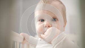 Infant baby bitting her finger. Child finger in mouth