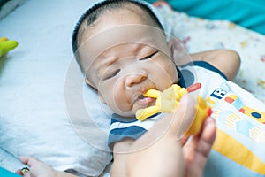 Infant baby boy chewing on teething with rubber