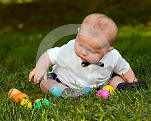 Infant baby boy playing with Easter eggs