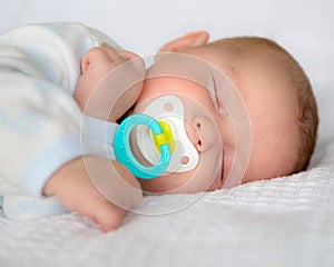 Infant baby boy sleeping with pacifier