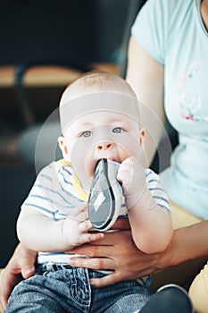 Infant Baby Child Boy Six Months Old is Takes his Shoe in the Mouth