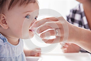 Infant baby girl drinks water from baby cup