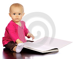 Infant baby girl enjoying and discovering books