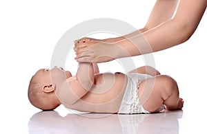 Infant baby girl kid in diaper is lying on her back start doing exercises to neck, torso lifts with adult coach