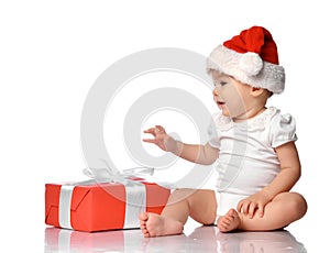 Infant baby in red Santa cap with gift box side view