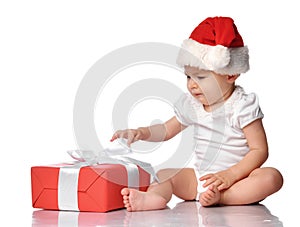 Infant baby in red Santa cap with gift box side view
