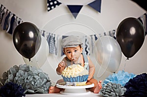 Infant boy`s first birthday cake smash Adorable baby smashing cake