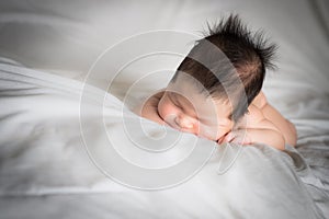 Infant boy sleeping on white bed