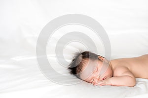 Infant boy sleeping on white bed