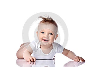 Infant child baby boy kid with blue eyes happy smiling screaming lying on a floor isolated on a white background