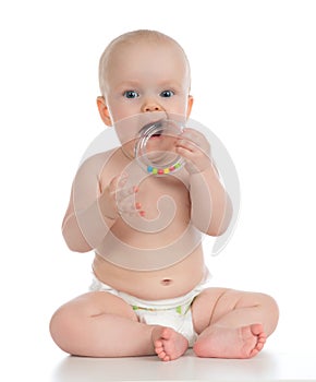 Infant child baby boy toddler playing and eating with circle ring toy in hand