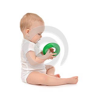 Infant child baby boy toddler playing holding green circle in ha