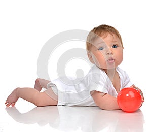 Infant child baby boy toddler playing with red ball toy in hands