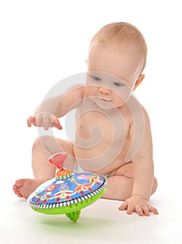 Infant child baby boy toddler playing with whirligig toy on a fl