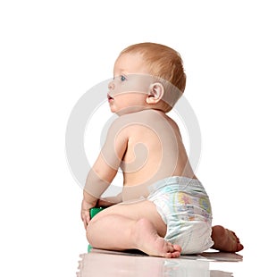 Infant child baby boy toddler sitting in diaper with green brick toy looking up