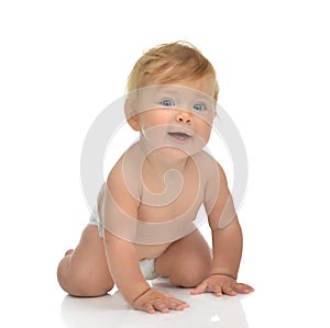 Infant child baby girl in diaper crawling happy looking at the c