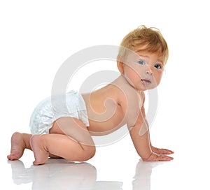 Infant child baby girl in diaper crawling happy looking at the c