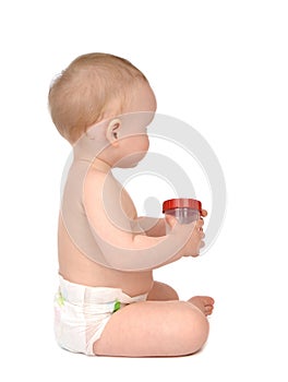 Infant child baby girl in diaper sitting backward with empty plastic sample can for analysis