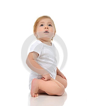 Infant child baby girl in diaper sitting and happy looking up