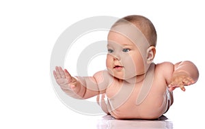 Infant child baby girl kid in diaper is lying on her tummy, stomach holding hands up, slapping on floor