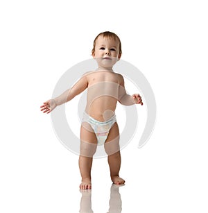 Infant child baby girl kid toddler in diaper make first steps photo