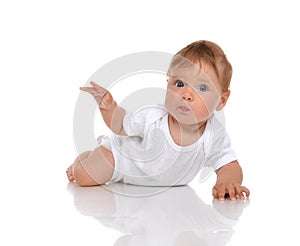 Infant child baby girl lying surprised with hand pointing