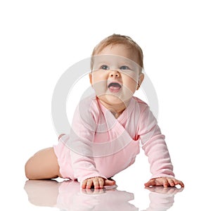 Infant child baby girl toddler lying in pink shirt learning to crawl happy screaming on a white