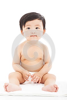 Infant child baby sitting on a white
